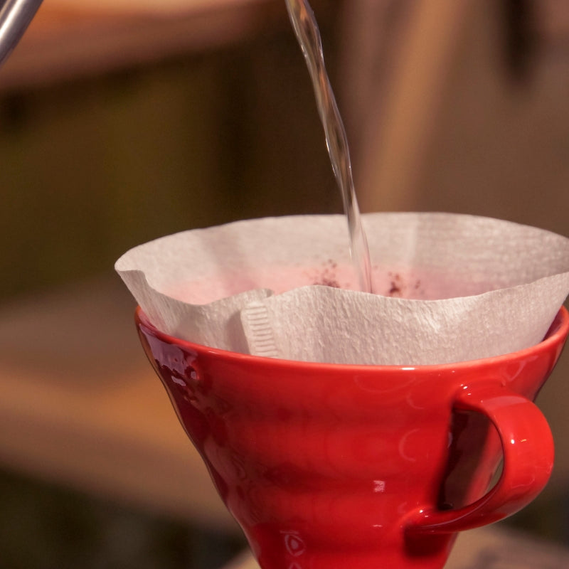 Kaffeetasse in die Wasser eingegossen wird, mit Kaffeefilter