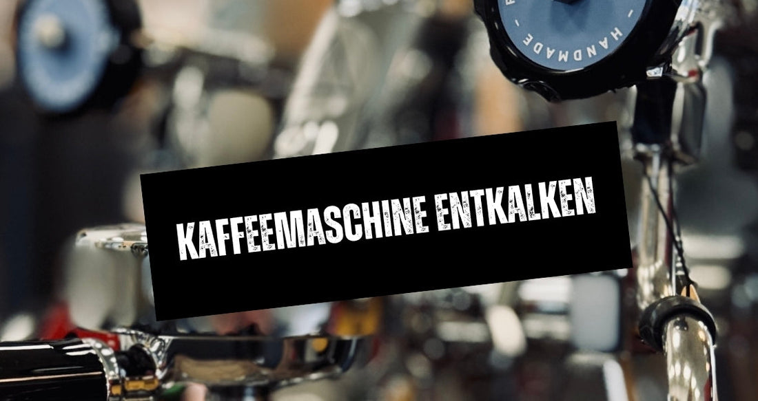 Silberne Siebträgermaschine mit blauen Rädern und einem „Handmade“-Schriftzug.