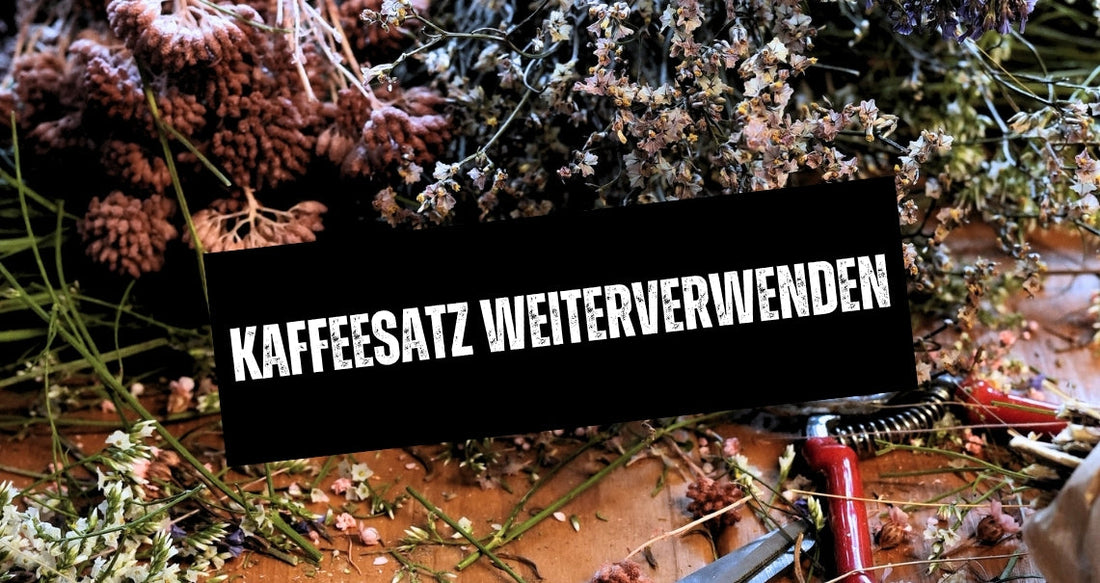 Blumen und Trockenblumen liegen auf einem Holztisch neben einer Gartenschere.