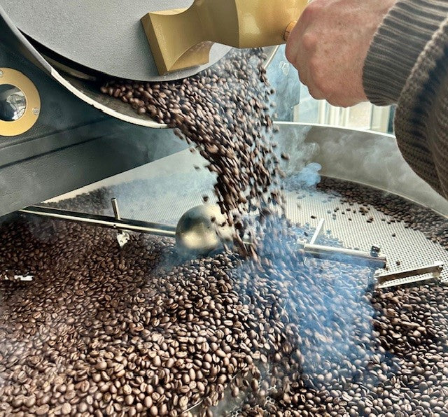 Frisch gerösteter Kaffee mit duftendem Dampf, der umgekippt wird